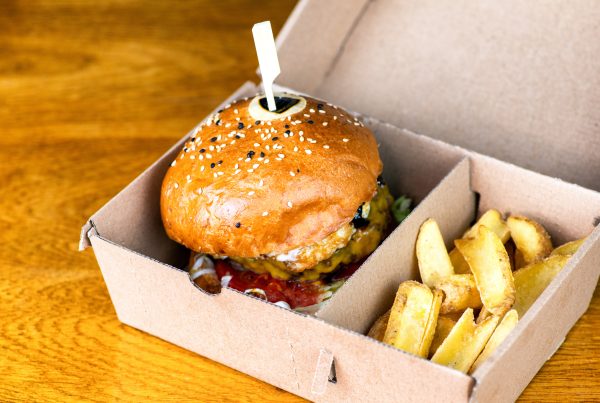 A burger and fries in a custom corrugated catering box.