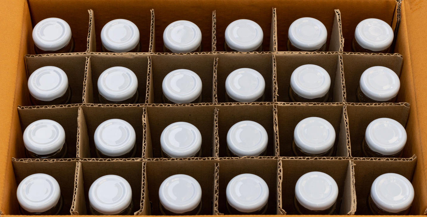 A closeup of bottles in corrugated packaging, depicting food and beverage packaging services